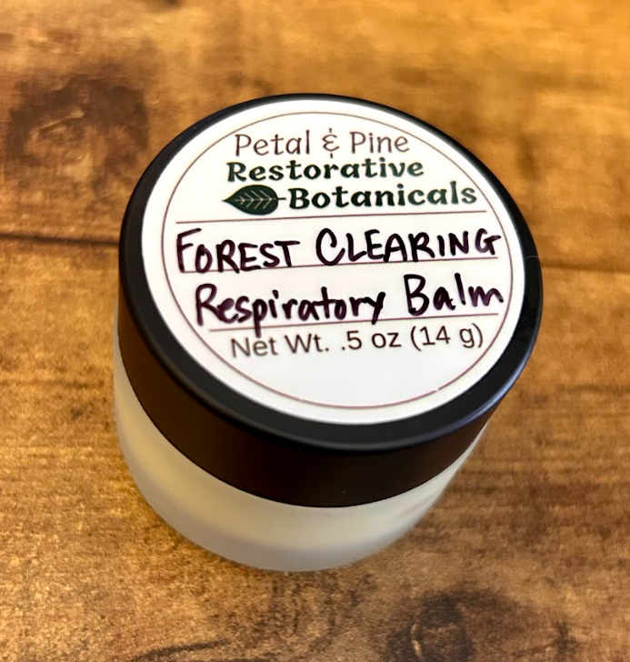 Jar of 'Forest Clearing Respiratory Balm' by Petal & Pine on a wooden surface