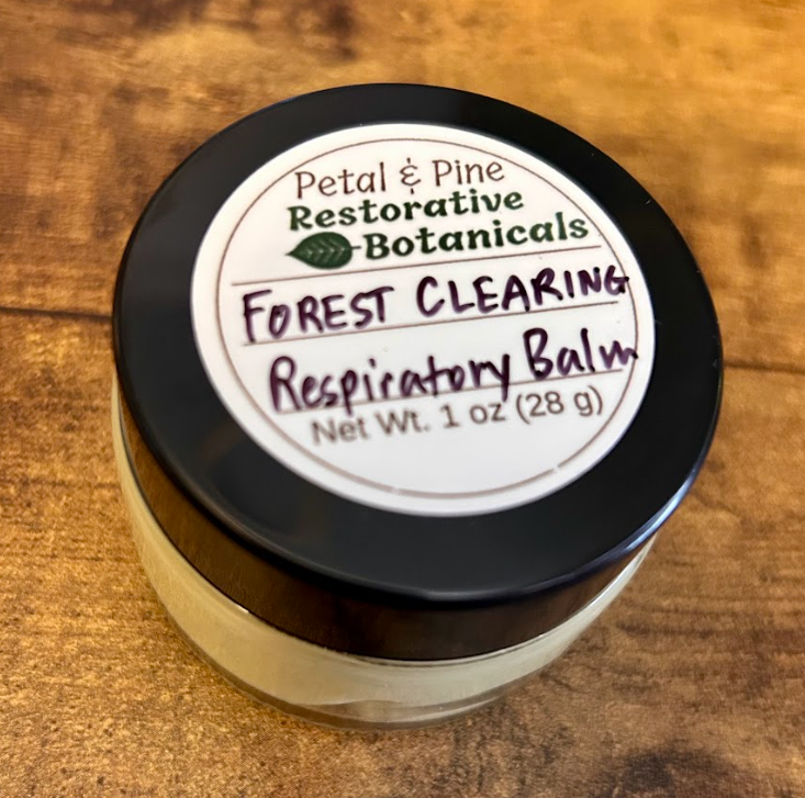 Jar of 'Forest Clearing Respiratory Balm' by Petal & Pine on a wooden surface