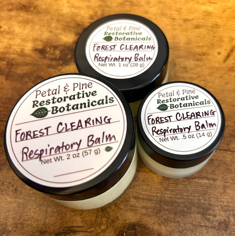Three containers of Petal & Pine Restorative Botanicals Forest Clearing Respiratory Balm on a wooden surface.