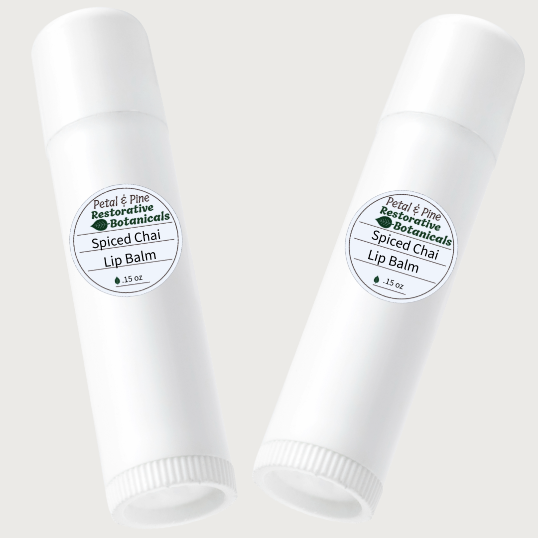 Two white lip balm tubes with Petal & Pine Spiced Chai labels on a light gray background