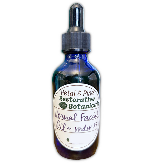 Blue glass bottle with dropper labeled 'Petal & Pine Restorative Botanicals' on a white background