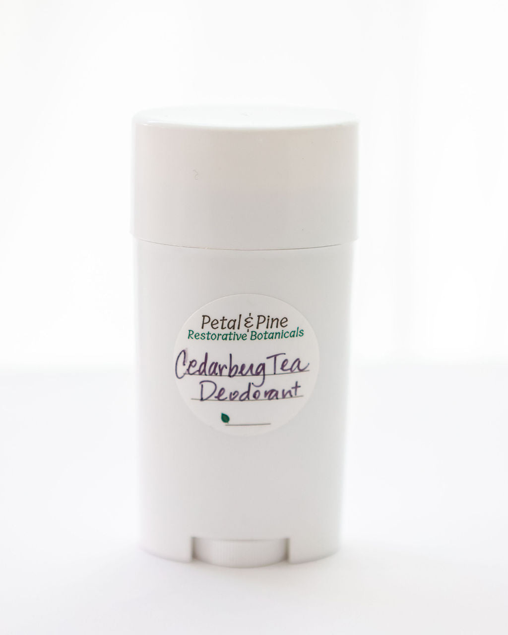 "Cedarberg Tea" is the name of the Tea Tree, Cedarwood, Bergamot All Natural Deodorant with a Petal & Pine Restorative Botanical Sticker on a light beige background