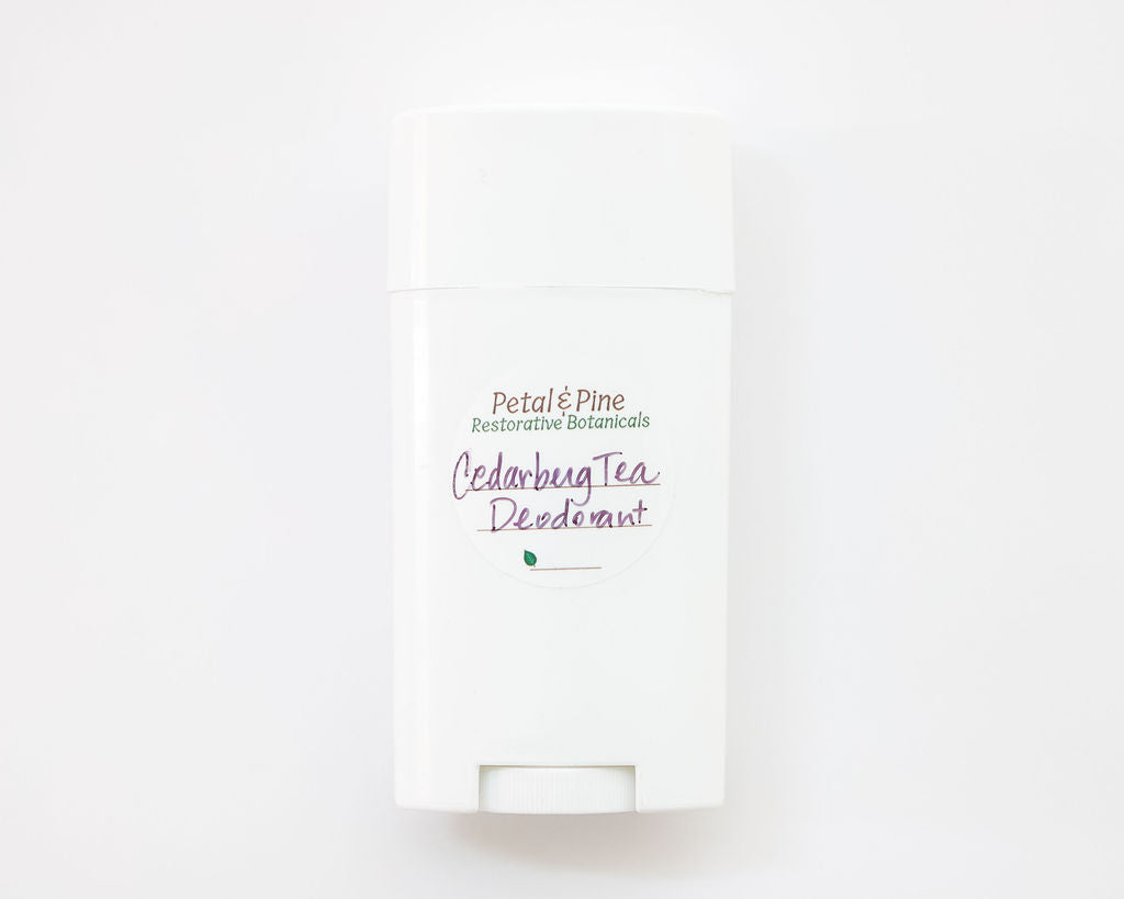 "Cedarberg Tea" is the name of the Tea Tree, Cedarwood, Bergamot All Natural Deodorant with a Petal & Pine Restorative Botanical Sticker on a light beige background