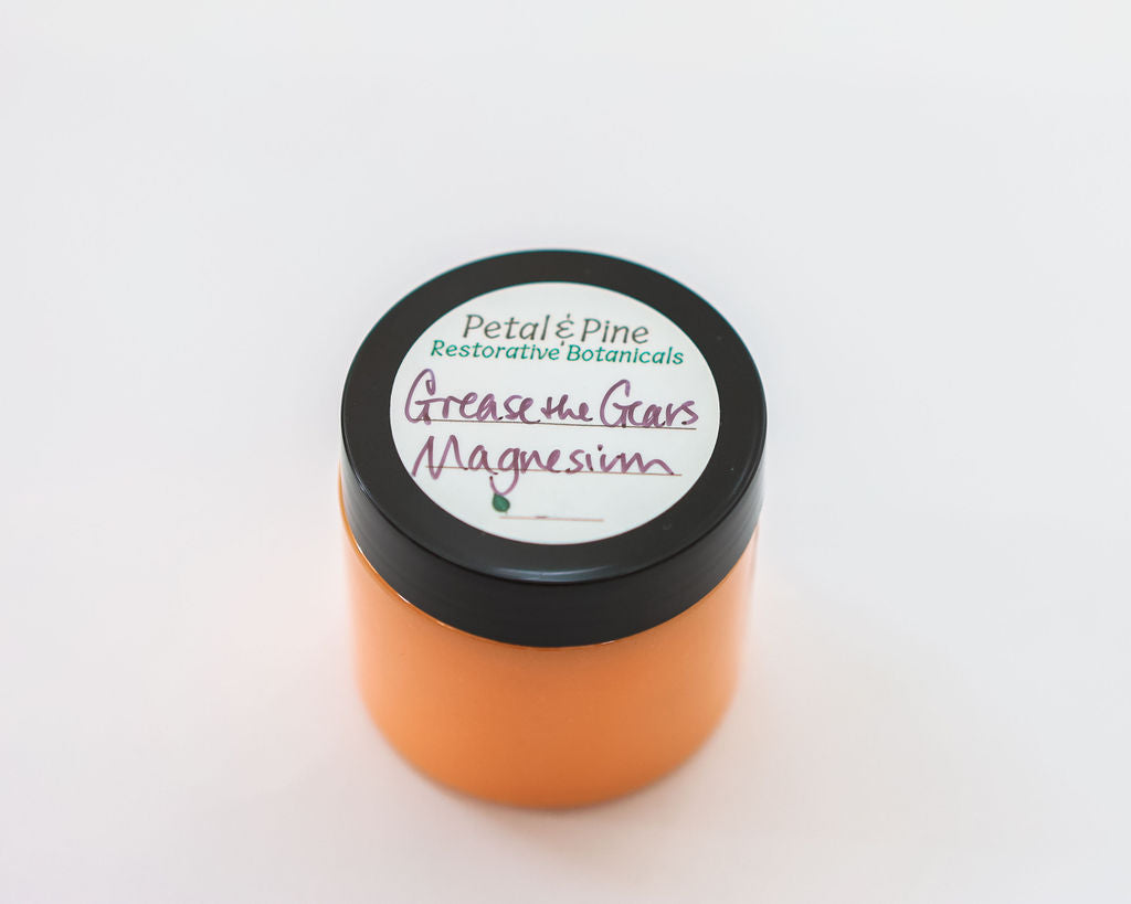 Orange jar with black lid labeled 'Petals & Pine' on a white background