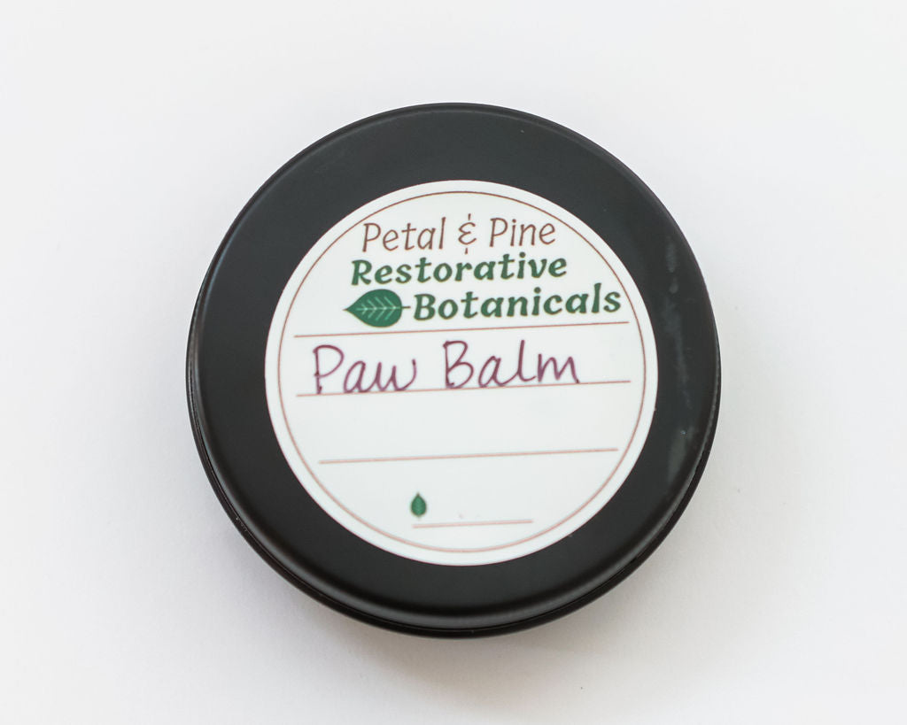 Paw balm container with 'Petal & Pine Restorative Botanicals' label on a white background