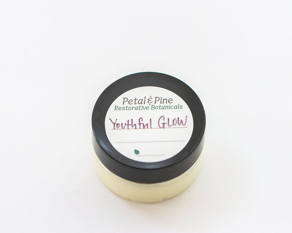 Jar of 'Youthful Glow' cream with 'Petal & Pine' label on a white background